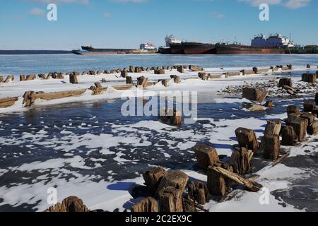 remains of a wooden pier and ships in port Stock Photo