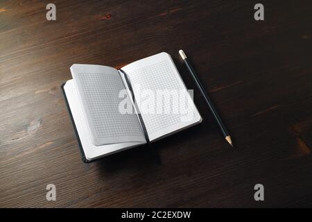 Opened blank notebook and pencil on wood table background. Copy space for text. Stock Photo