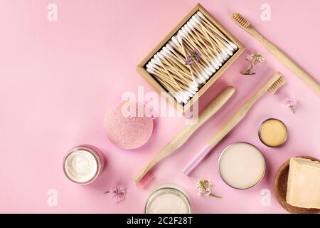 Plastic-free, zero waste cosmetics, flat lay on a pink background. Bamboo toothbrushes and cotton swabs, konjac sponge, natural Stock Photo