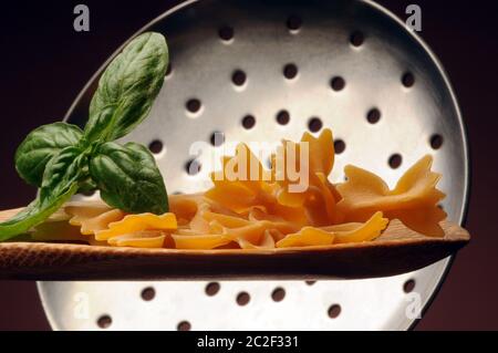 Uncooked farfalle pasta on the spoon Stock Photo