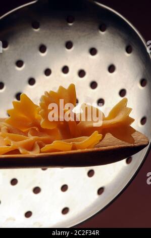 Uncooked farfalle pasta on the spoon Stock Photo