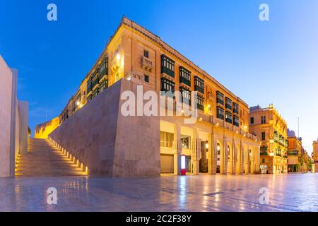 The traditional Maltese street, stairs and building with colorful balconies near Valletta City Gate in Old Town of Valletta, Capital city of Malta Stock Photo