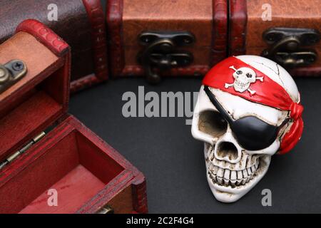 Skeleton pirate with treasure chest on dark background Stock Photo