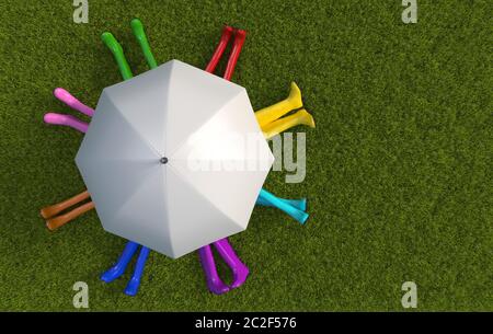 Many friends people in multi-colored rubber boots are sitting on the green lawn covered with grass under a white umbrella in rainy weather. Top view. Stock Photo