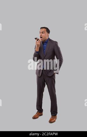 Businessman Angry Talking on Phone Isolated. Indian Businessman Yelling on Phone Standing Full Length Stock Photo