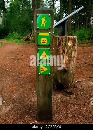 wooden sign post mile marker on a hiking jogging trail in a forest nature Stock Photo