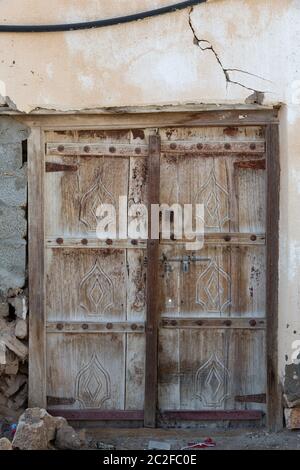 Weathered brown wooden door in town of Al Ayjah near Sur, Oman Stock Photo