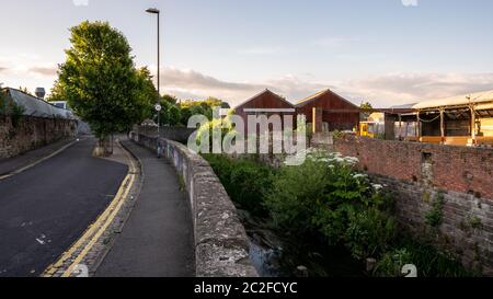 The River From flows alongside Wellington Road, part of the Frome Greenway and Concorde Way 'greenway' cycle routes, and the Pennywell Road industrial Stock Photo