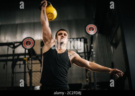 Athletic muscular man with perfect beautiful body wearing sportswear lifting heavy free weights Stock Photo