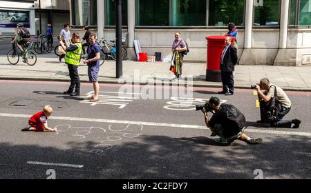 London, England, UK - May 17, 2014: A child writes slogans on a street as part of a protest road through central London as part of the London Cycling Stock Photo