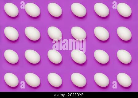 White eggs arranged on solid color background Stock Photo