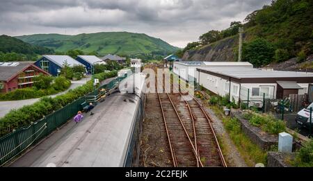Machynlleth, Wales, UK - June 21, 2012: A passenger train calls of Machynlleth Station under the hills of mid Wales on the Cambrian Line railway. Stock Photo