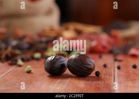 Nutmeg or Jaiphal is an aromatic spice placed over a wooden background, selective focus Stock Photo