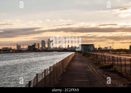 London, England, UK - July 31, 2010: The sun sets behind the skyline of London's Docklands business district and the wastegrounds of the disused Royal Stock Photo