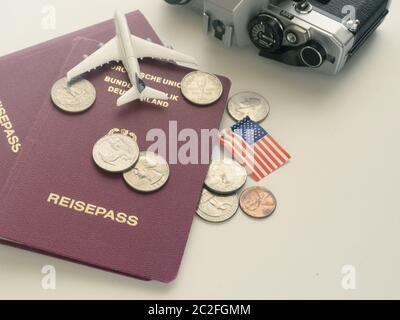 Travel concept with German passport und American flag and coins on a table Stock Photo