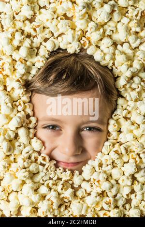 Creative portrait of a boy with his face surrounded by popcorn. Stock Photo