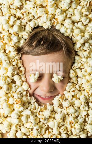 Creative portrait of a boy with his face surrounded by popcorn. Stock Photo