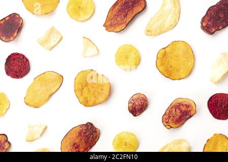 Dry fruit and vegetable chips, healthy vegan snack, an organic food flat lay pattern on a white background Stock Photo