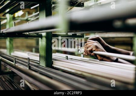 Iron and steel materials in different shape and forms lying on shelves. Storage for raw stuff on metalurgic plan. Close up, blur background. Stock Photo