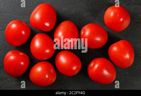 Top down view, dozen of mini tomatoes on black stone desk Stock Photo