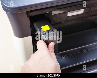 installing new toner cartridge in laser multi function device on table in office Stock Photo
