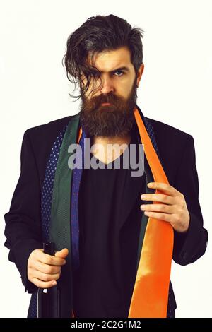Bearded man, long beard. Brutal caucasian hipster with moustache in black suit with colorful ties on shoulders holding bottle isolated on white studio background Stock Photo
