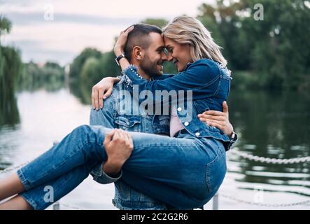 Happy couple enjoy each other on nature. Man holding woman on hands Stock Photo