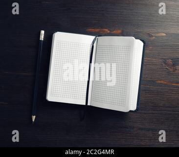Opened blank notepad and pencil on wooden background. Flat lay. Stock Photo