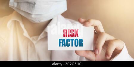 Doctor holding a card with Risk factor medical concept Stock Photo