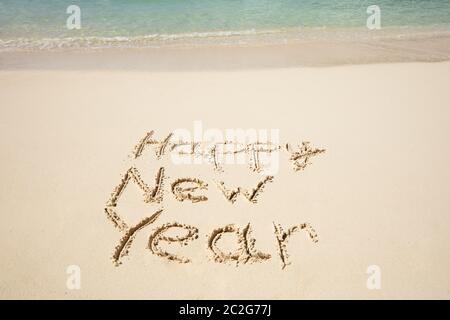 Happy New Year Text Written On Sand Near The Sea At Beach Stock Photo