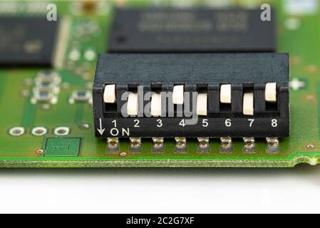 Analog switch on a green printed circuit board with eight positions, adjustable up and down. Stock Photo
