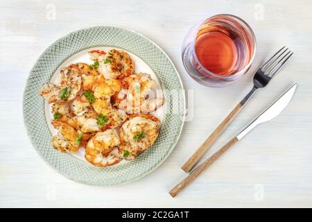 Fired shrimps with a glass of rose wine, shot from the top on a light blue background Stock Photo