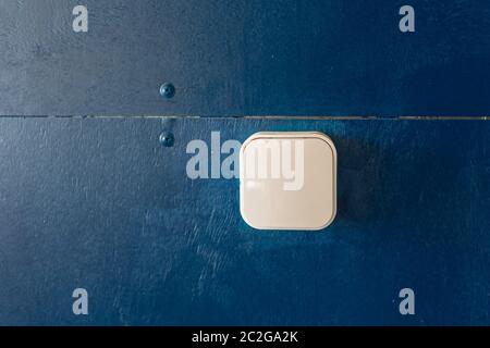 white plastic light switch on a blue wall Stock Photo