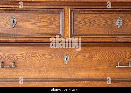 old antique old mahogany chest of drawers in a room with additional decor Stock Photo