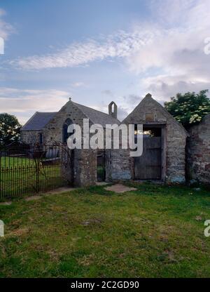 View SW of St Baglan's Church, Llanfaglan, Caernarfon, Wales, UK, showing the lychgate dated 1722 & the T-shaped church with C13th/14th nave. Stock Photo