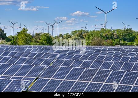 Solar panels with wind turbines in the back seen in Germany Stock Photo