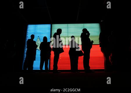 San Antonio Texas USA, March 25 2016: People standing in line at the  Institute of Texan Cultures are silhouetted against a large neon rendering of a Texas flag. ©Bob Daemmrich Stock Photo