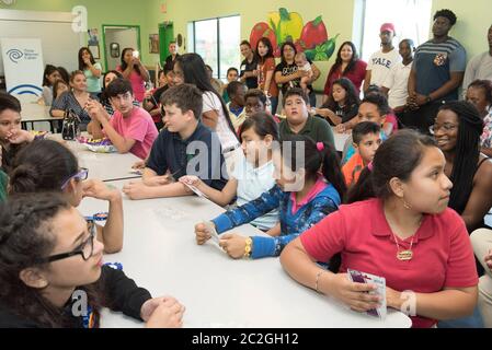 Austin Texas USA, April 20 2016: Middle school students and adult volunteers crowd into Cedars International Academy cafeteria to hear instructions for upcoming design-build challenge using recycled cardboard boxes. The event was held on Earth Day.  ©Bob Daemmrich Stock Photo