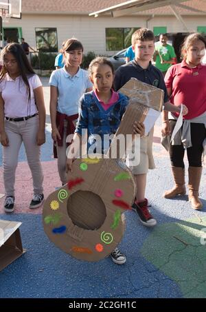 Austin Texas USA, April 20 2016: Students at Cedars International Academy, competing in the Earth Day Cardboard Challenge program at Cedars International Academy, design and build a science display out of cardboard and other simple recycled products. The event was held on Earth Day. ©Bob Daemmrich Stock Photo