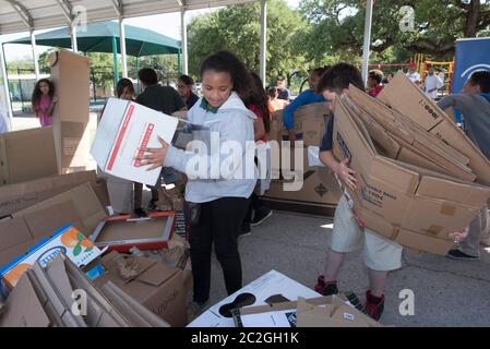 Austin Texas USA, April 20 2016: Students at Cedars International Academy, competing in the Earth Day Cardboard Challenge program at Cedars International Academy, design and build a science display out of cardboard and other simple recycled products. The event was held on Earth Day. ©Bob Daemmrich Stock Photo