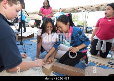 Austin Texas USA, April 20 2016: Students at Cedars International Academy, competing in the Earth Day Cardboard Challenge program at Cedars International Academy, design and build a science display out of cardboard and other simple recycled products. The event was held on Earth Day. ©Bob Daemmrich Stock Photo