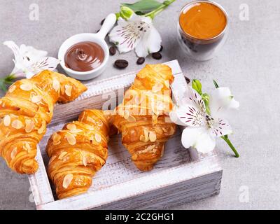 Yummy freshly three croissants sliced almonds with coffee and chocolate paste Stock Photo