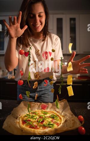 woman making pizza ingredients like salami mushrooms olive cheese freeze in air Stock Photo