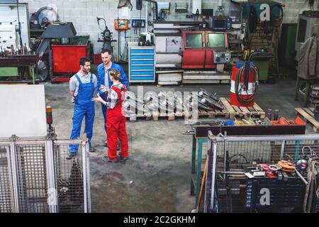 Workers on the factory floor in discussion seen from high viewpoint Stock Photo