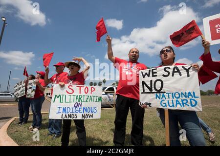 Weslaco, Texas USA< April 12, 2018: Protesters opposed to Gov. Greg Abbott's deployment of National Guard troops on the Texas border yell outside the Guard Armory in Weslaco. The guard members will assist federal Border Patrol agents in trying to slow illegal immigration at the United States' southern border. The protesters object to the government militarizing their towns. ©Bob Daemmrich Stock Photo