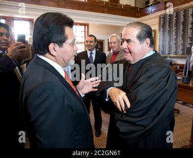 Austin Texas USA, November 11 2013: U.S. Supreme Court Justice Antonin Scalia (right) visits with former U.S. Attorney General Alberto Gonzales, as he takes part in the investiture of Texas Supreme Court Chief Justice Nathan Hecht at the Texas Capitol. Scalia is the longest serving justice currently on the Supreme Court.   ©Bob Daemmrich Stock Photo