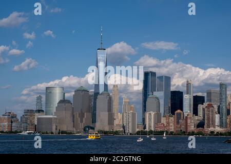 Lower Manhattan skyline with boat and ferry on Hudson river view from Liberty State Park in late summer Stock Photo