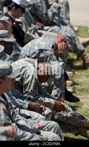 Fort Hood Texas USA, April 9 2014: U.S. Army soldiers bow their heads during President Barack Obama's speech at a memorial service for three Fort Hood soldiers killed in last week's shooting.   ©Bob Daemmrich Stock Photo