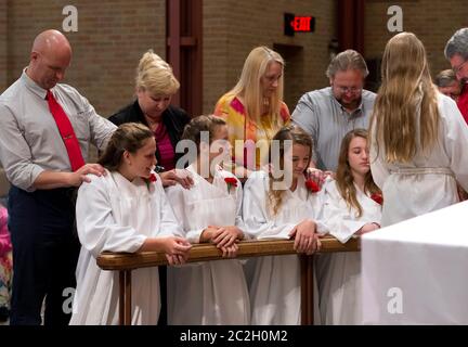 Austin Texas USA, June 8 2014: With their parents standing behind them, Lutheran teenagers at St. Martin's Lutheran Church participate in the Rite of Confirmation, a public profession of faith during a ceremony before the congregation.   ©Bob Daemmrich Stock Photo