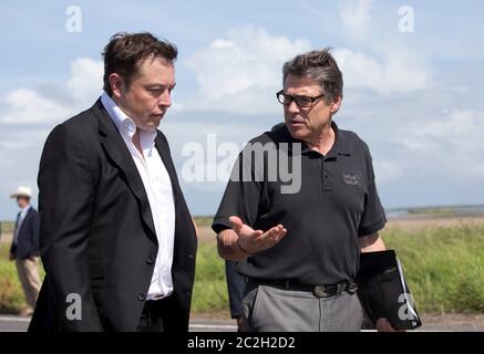 Boca Chica Texas USA, September 23 2014: SpaceX CEO Elon Musk (left) chats with Texas Gov. Rick Perry as they walk to the groundbreaking ceremony on the site of the company's new space port in far south Texas. The remote site east of Brownsville, Texas is two miles from the mouth of the Rio Grande River and Texas' border with Mexico.  ©Bob Daemmrich Stock Photo